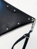 the back side of handmade leather purse, showing chrome rivet detail.